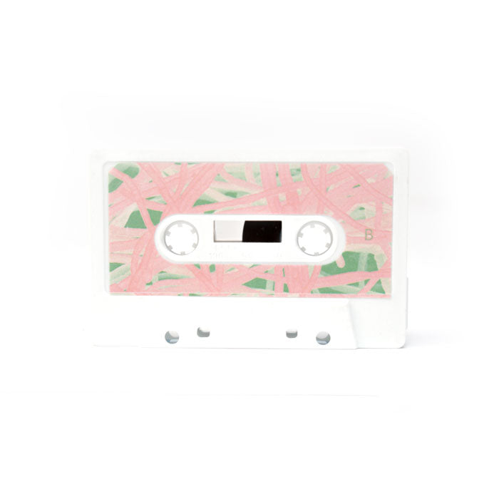Cassette tape with pink and green leaf pattern on a white background