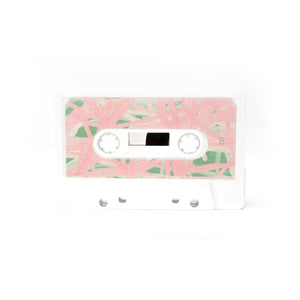 Cassette tape with pink and green leaf pattern on a white background