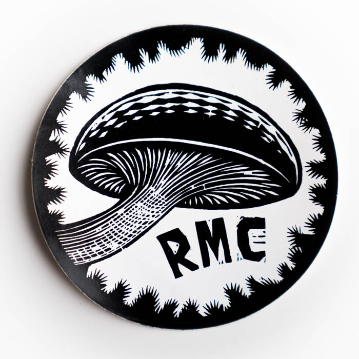 Circular black and white sticker with a mushroom design and 'RMC' text on a white background