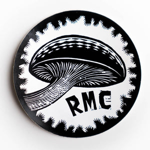 Circular black and white sticker with a mushroom design and 'RMC' text on a white background