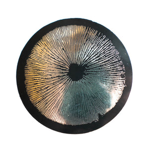 Circular sticker with spore print patterns on a silver background