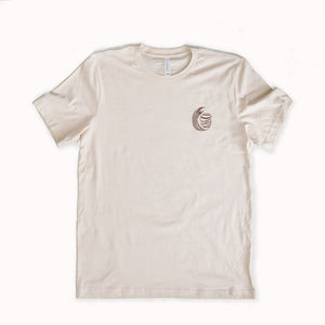 Beige t-shirt with a small logo on a white background