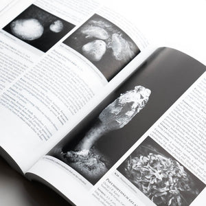 Open book with black and white images of mushrooms on a white background