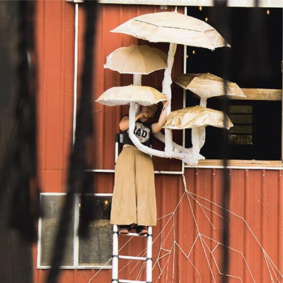 Person installing mushroom sculpture